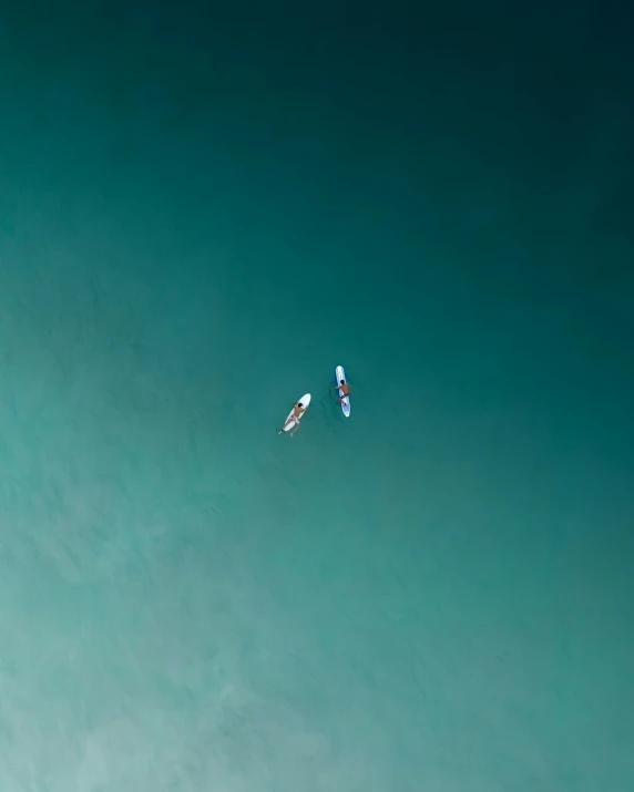 a couple of people on surfboards in the ocean