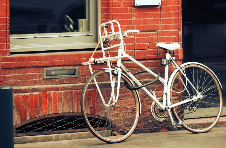 a bicycle parked on the sidewalk beside a building