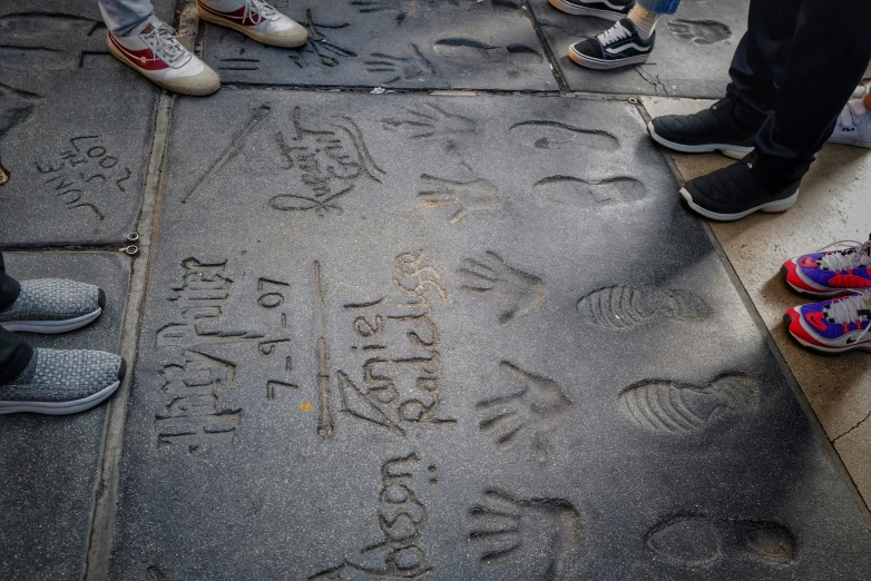 a sidewalk with a child and a group of children writing on the pavement