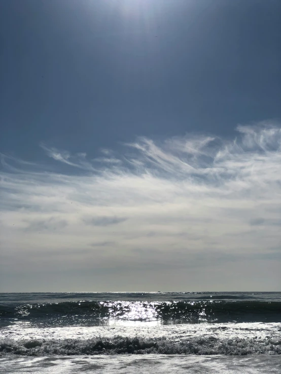 two people walk out onto the beach at sunset