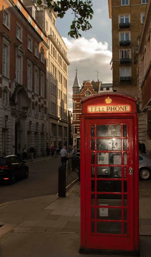 a red phone box on the side of a road