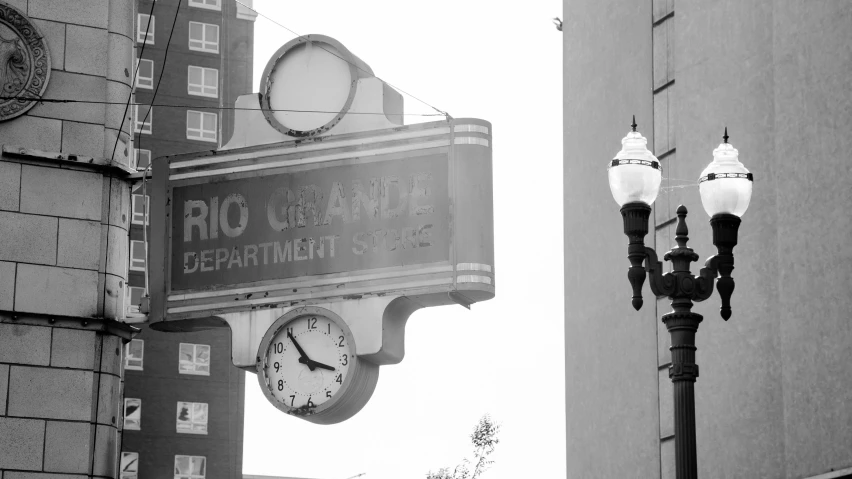 black and white pograph of two street lamps with a el sign on top