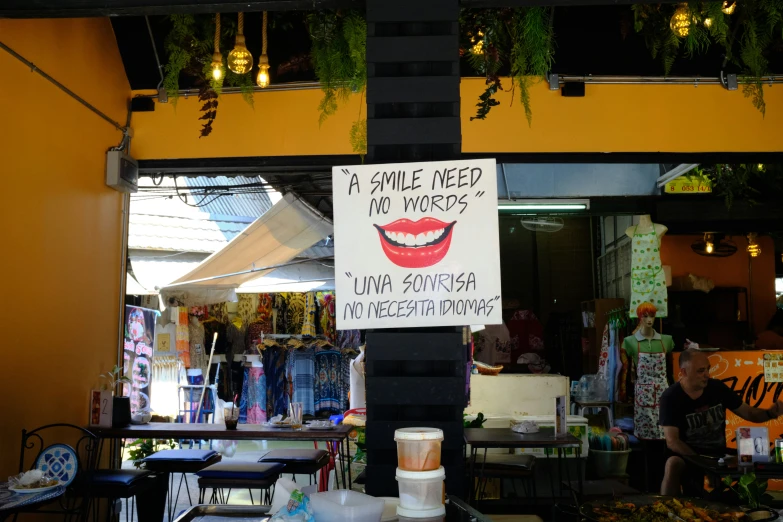 a sign on a pole at a street market