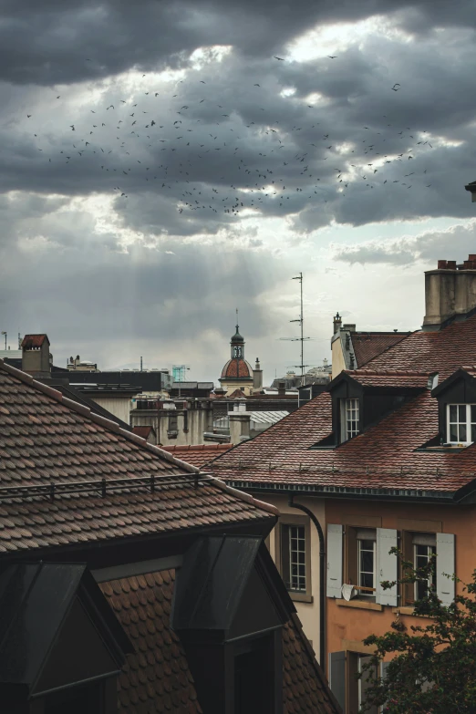 storm clouds loom above rooftops in the city