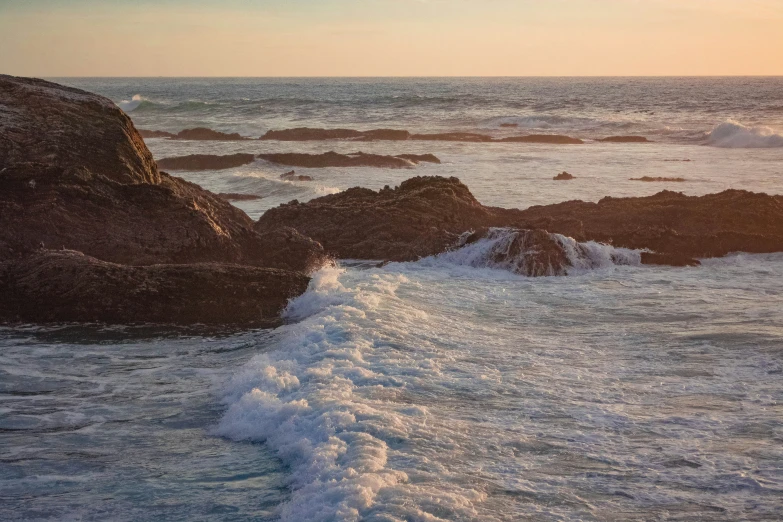 wave on the rocks at the ocean during sunset