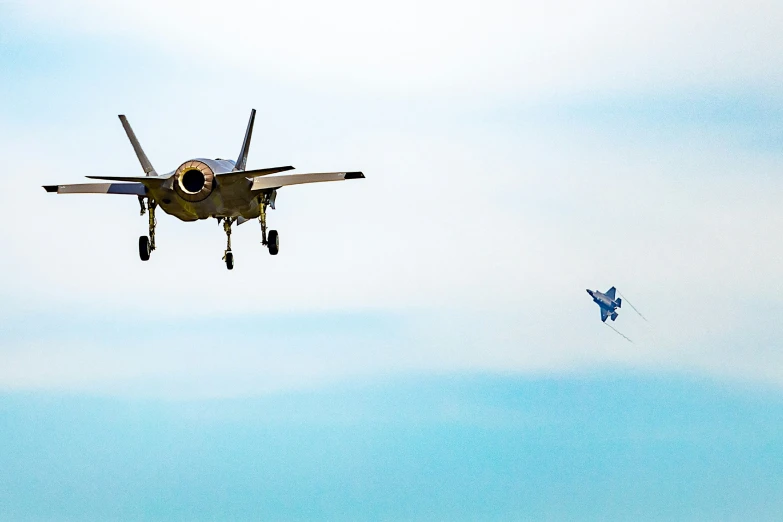 a fighter jet flying above a kite in the air