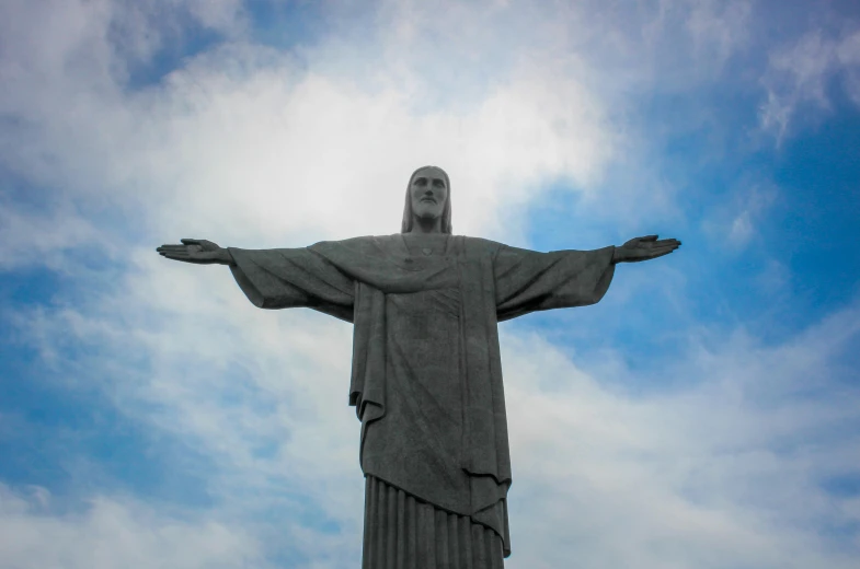 a man stands next to the base of a statue