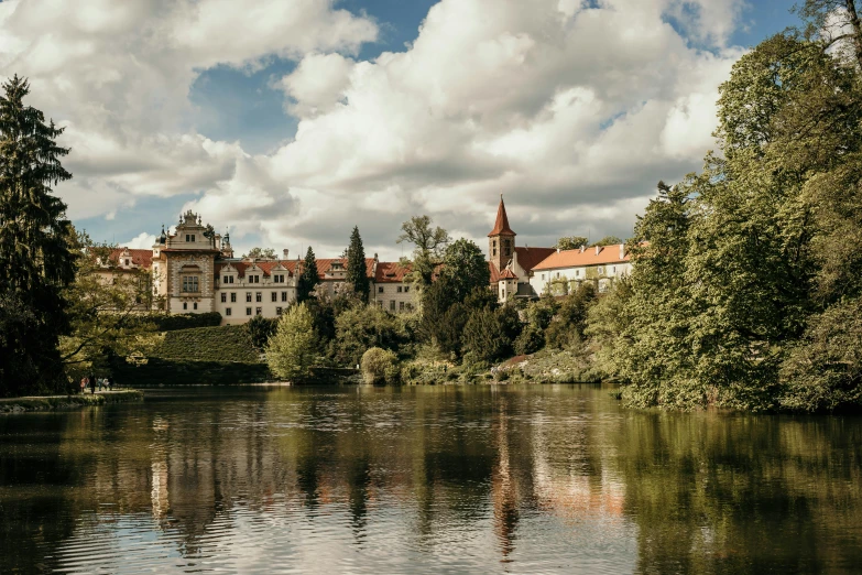 a river runs by a large city with a castle in the background