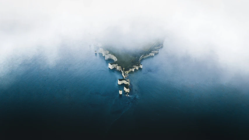 a bird flying over a cloudy, blue water