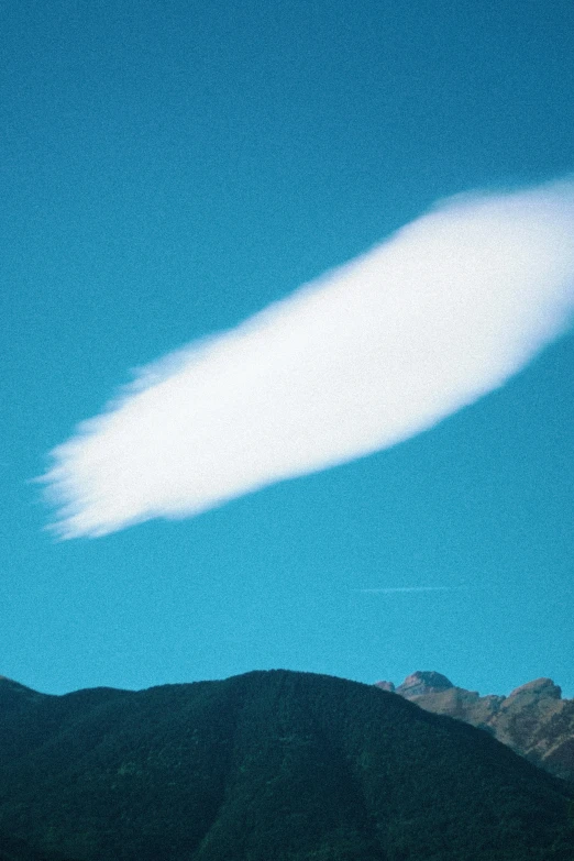 a big puff of white clouds in the middle of a blue sky