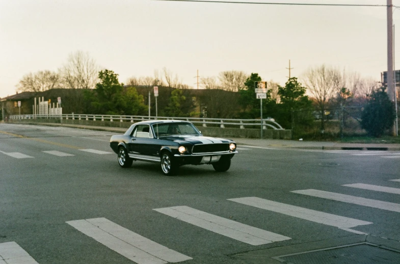 an old mustang is waiting at the red light