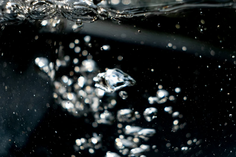 an ice cube under water, bubbles and bubbles