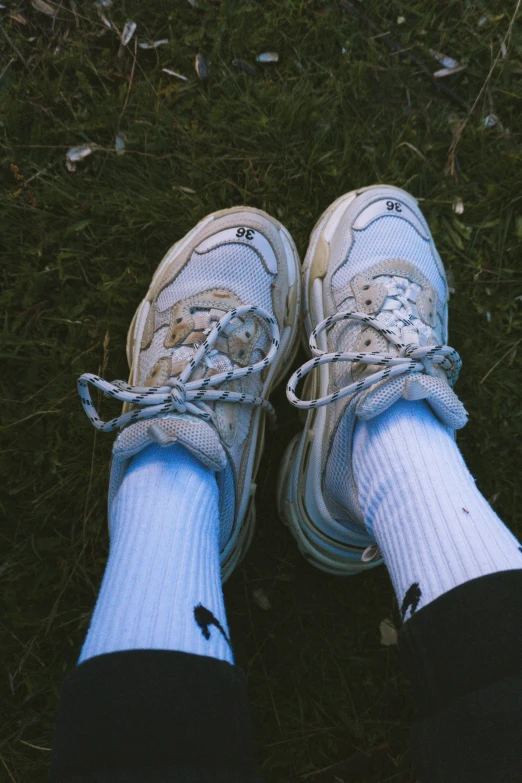 a woman wearing white shoes and blue socks and black pants