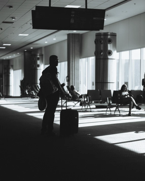 a man standing in an airport waiting to take his luggage
