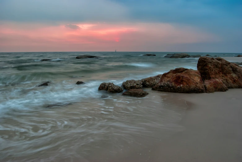 the waves have washed on the beach at twilight