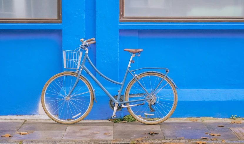a bicycle is parked next to a blue building