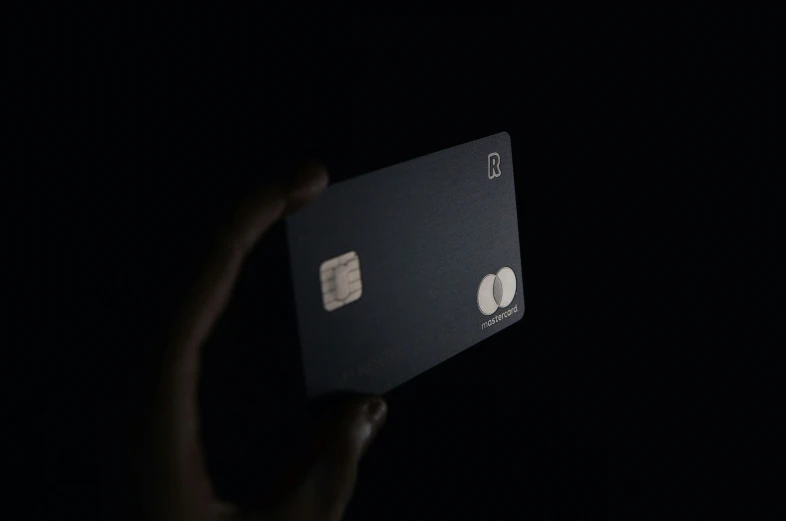 someone holds an electronic credit card up in the dark