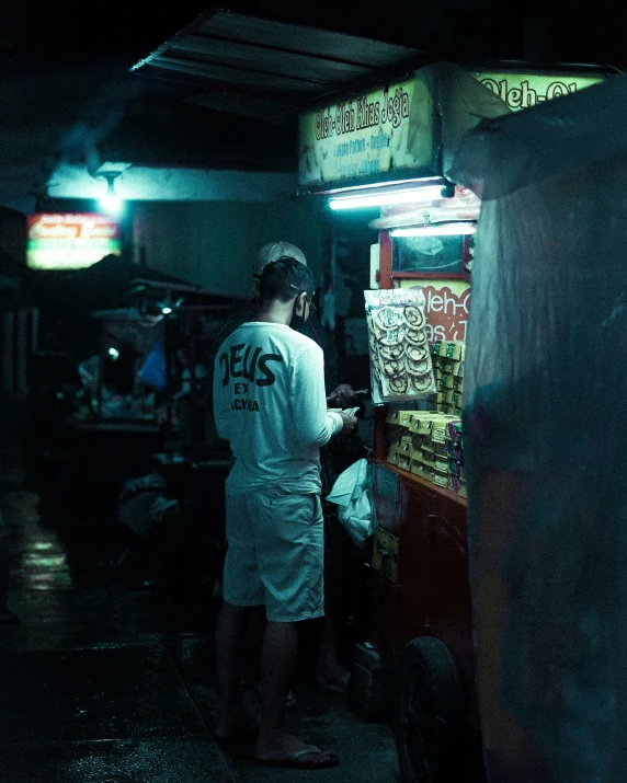 a person wearing a white shirt stands next to a vending machine