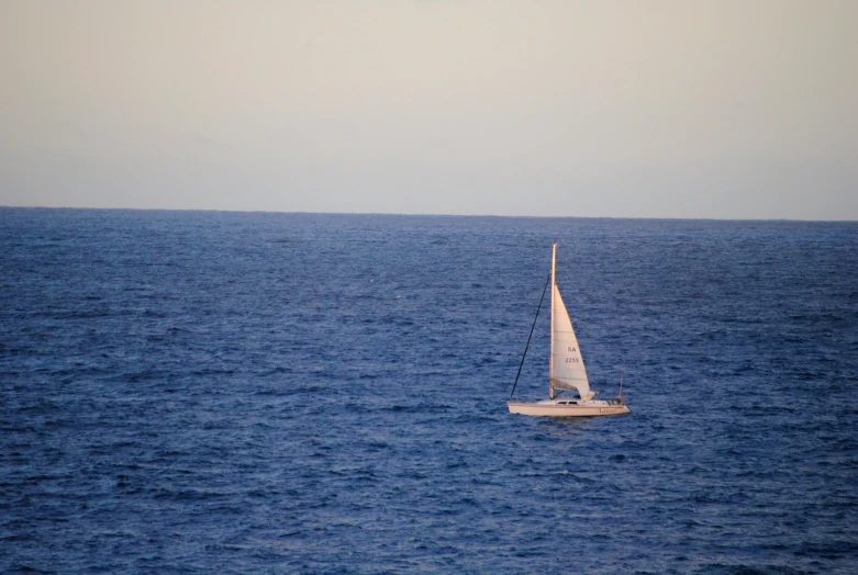 a sail boat out on the ocean waters