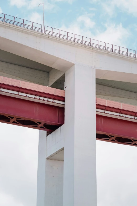 a red and white bridge that has a red beam above it