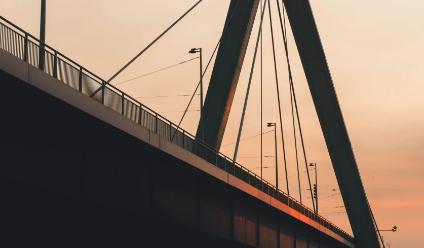 a very tall bridge with a clock in the background