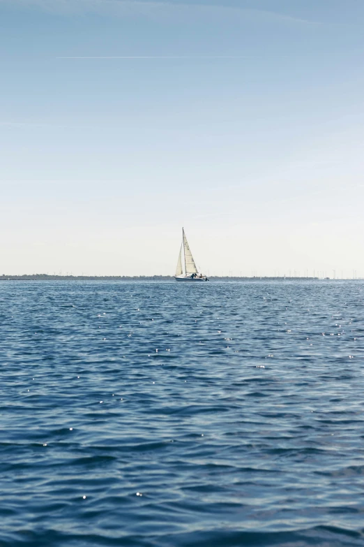 a white boat sailing on the ocean on a clear day