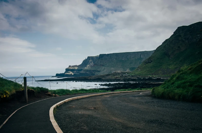 there is a curve in the road next to the ocean