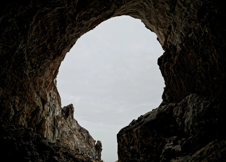 a person standing in a cave while looking at soing