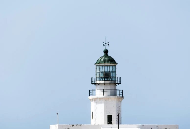 an white lighthouse sits on top of a building