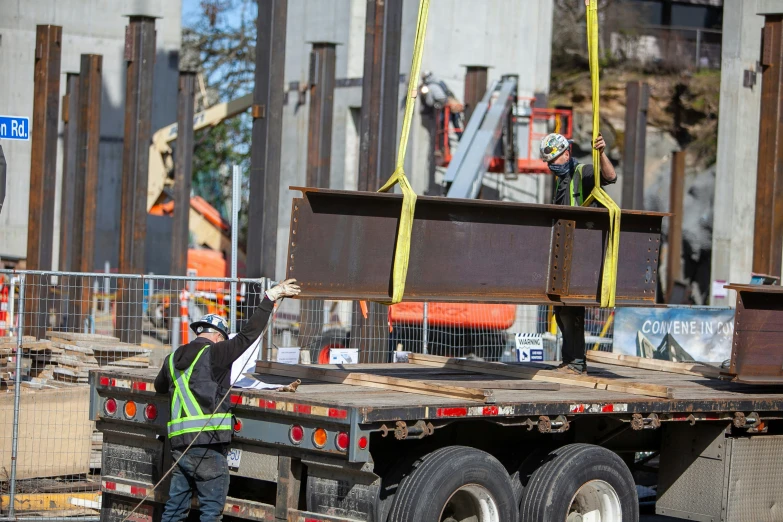 a construction worker is standing beside a big truck