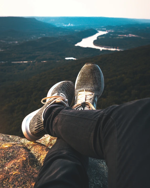 the person's legs and legs are in front of a mountain view