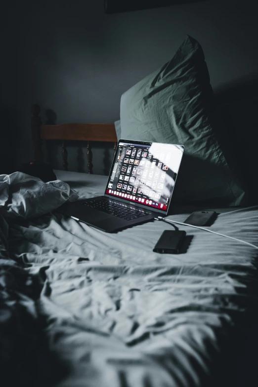 laptop open on a bed in black and white