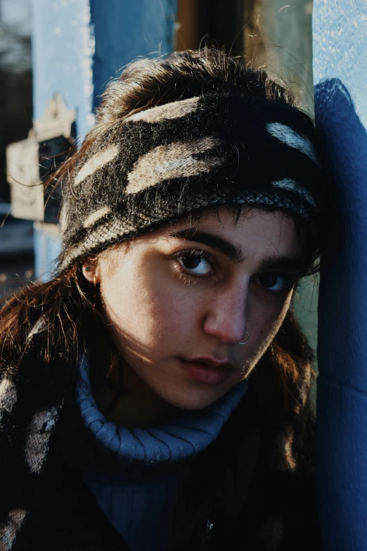 a girl wearing a scarf and head band with her eyes wide open