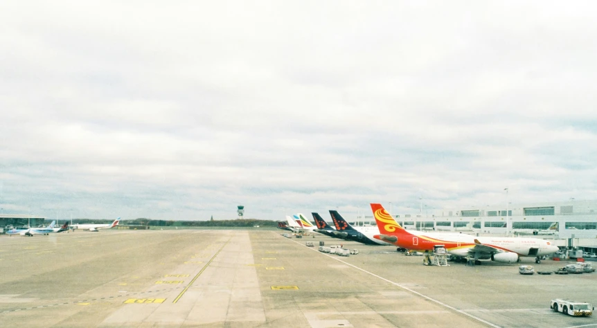 airplanes parked on an airport runway under cloudy skies