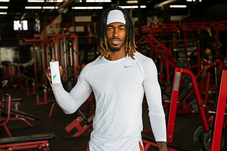 man with dreadlocks holding wii game controller in gym