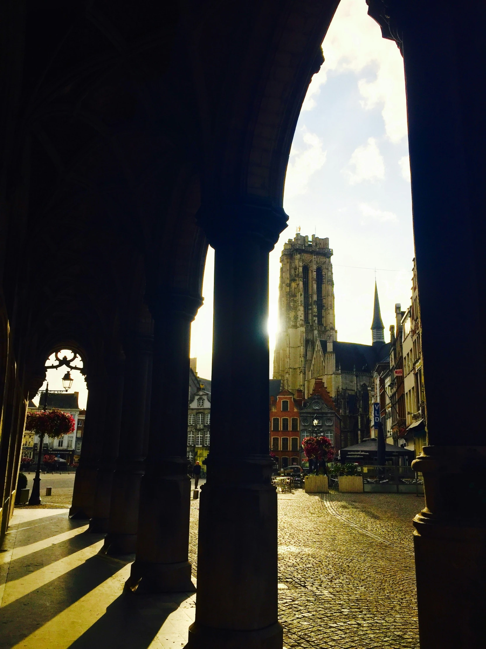 a street scene with a cathedral and sun coming through