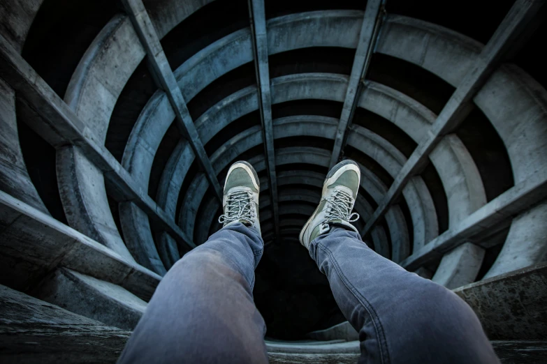 person standing in an open spiraled room with their feet on the ground