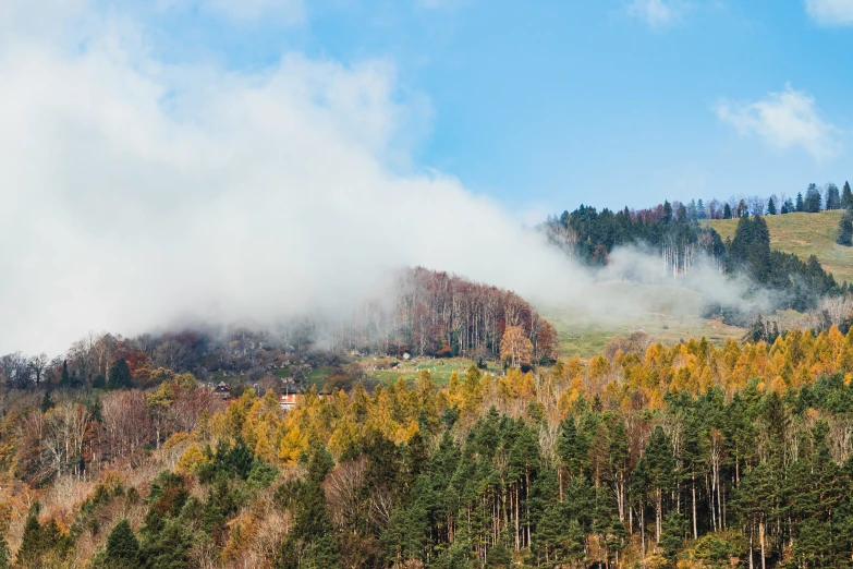 some clouds are above a mountain and forest