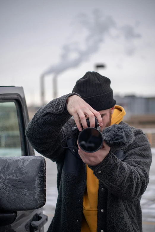 a man taking pictures with his cell phone in front of a truck