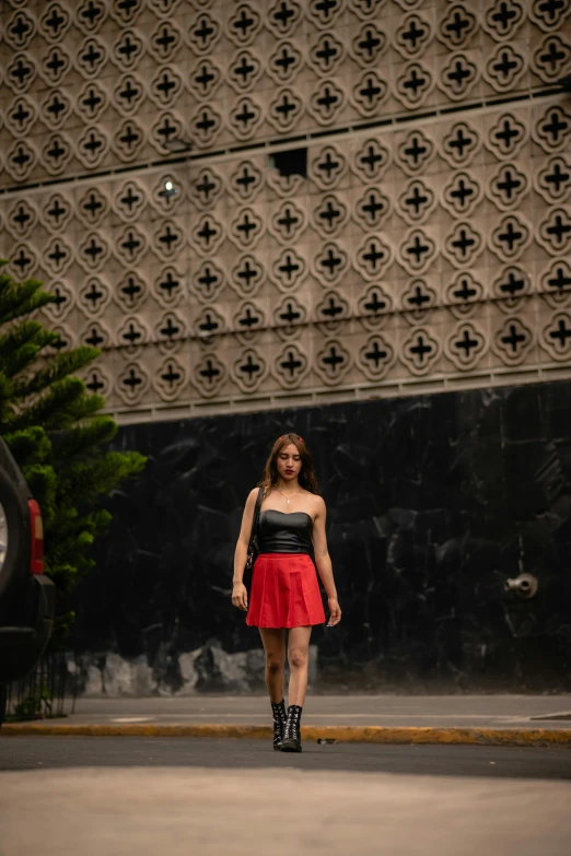 a woman wearing a short red skirt with black sleeves