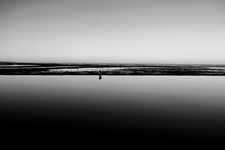 two people stand in the water, one walking