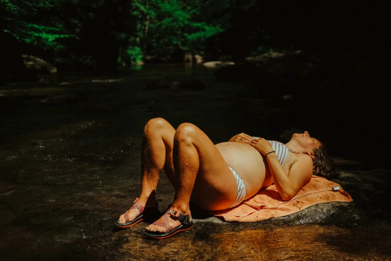 a woman laying down on a towel in the water