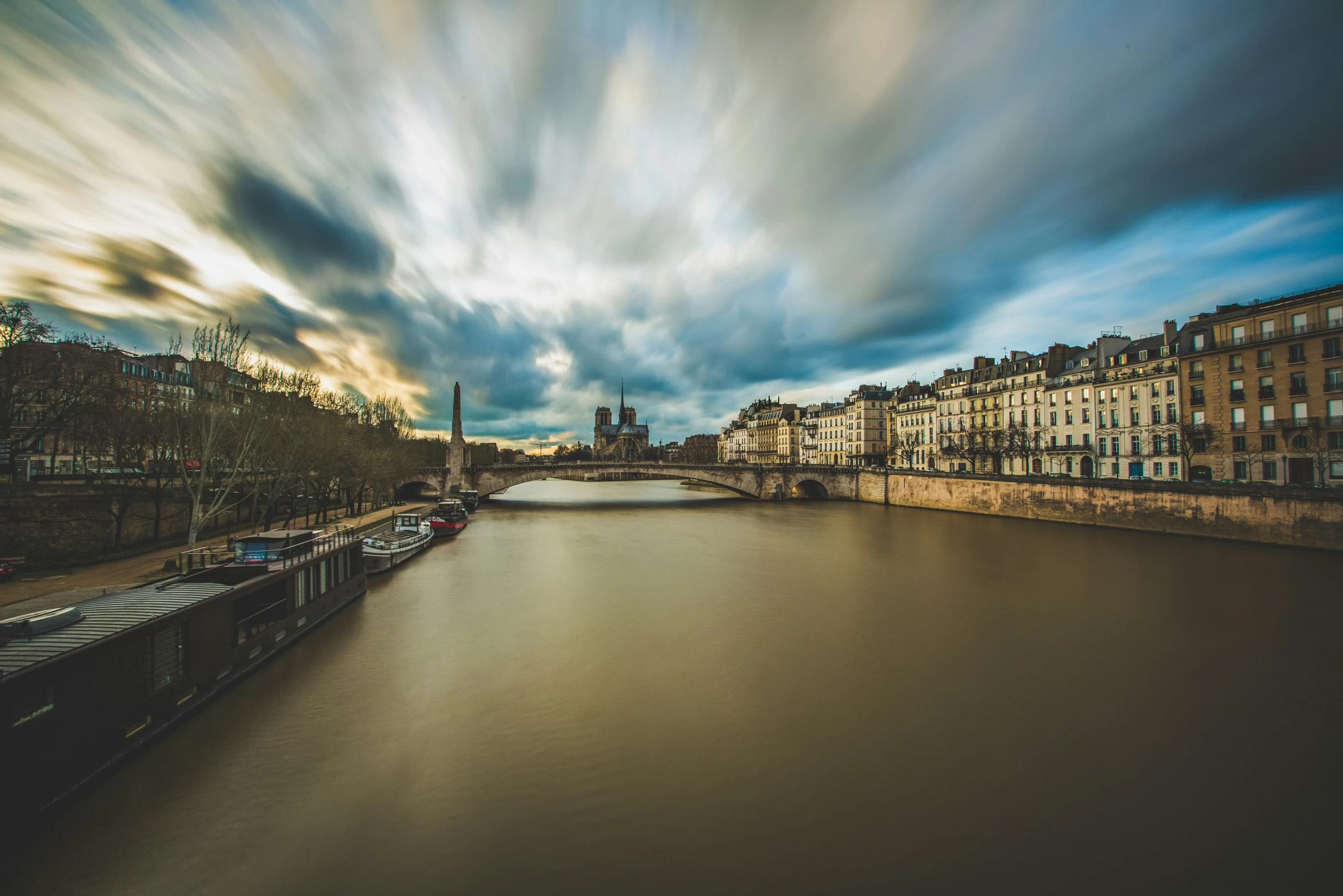 an overcast sky and some buildings on a river