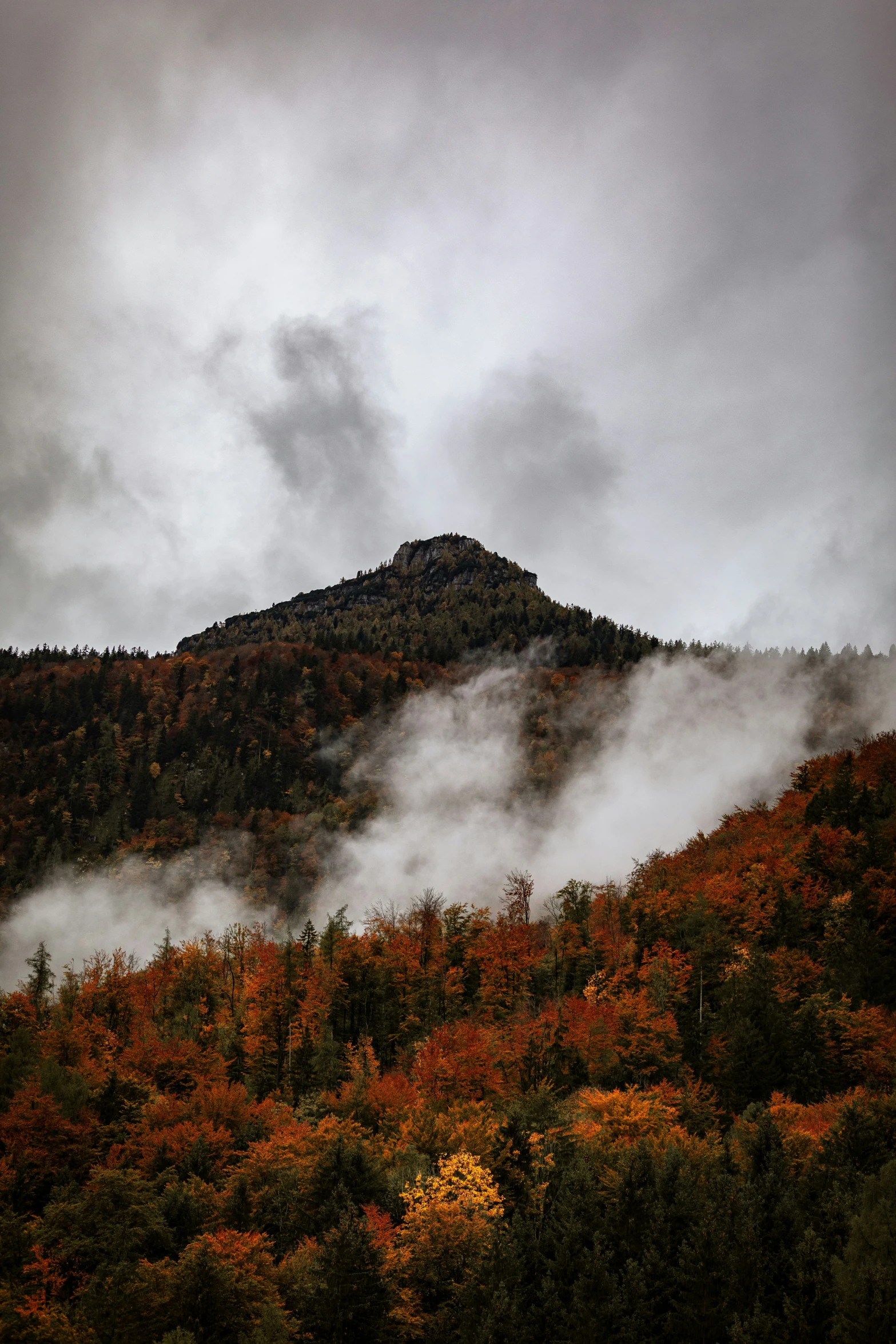 the fog hangs low over the mountains as it moves down