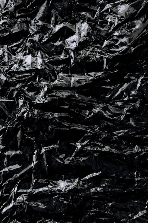 a large amount of black crumpled paper sitting on top of each other