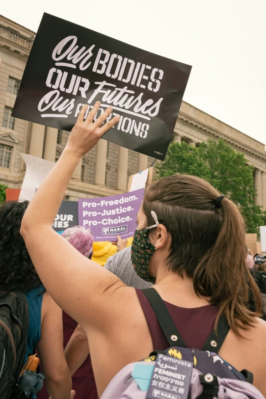 a person holds up a sign in front of an audience