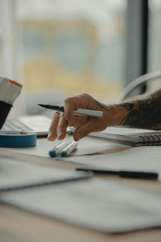 someone writing soing on top of a desk