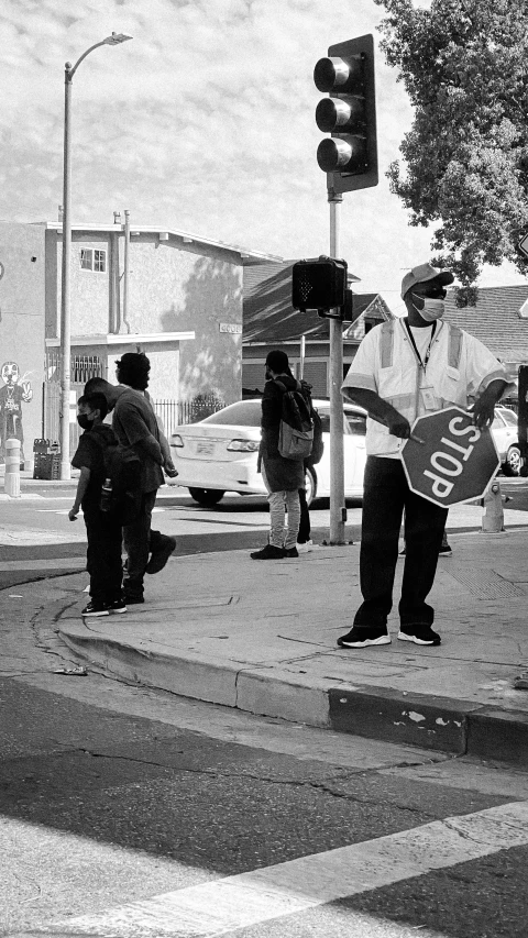 a black and white po shows a stop light with street musician