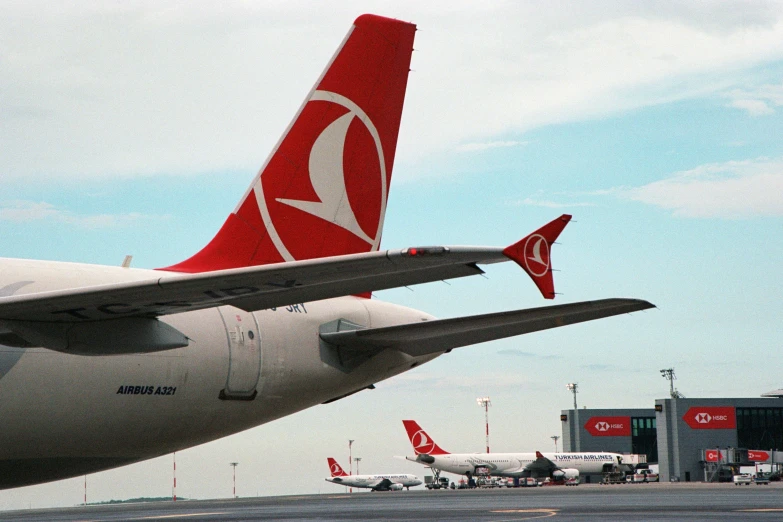 the tails of two commercial airliners are displayed on the tarmac