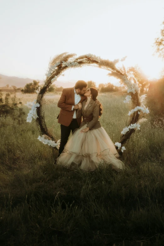 a young couple standing outside on the grass holding a flower